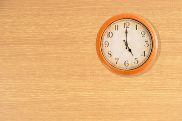 Clock showing 5 o'clock on a wooden wall
