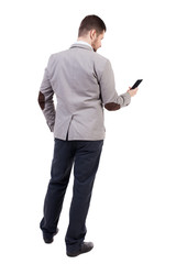  back view of business man in suit  talking on mobile phone.
