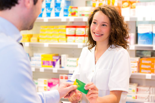 Attractive pharmacist taking healt insurance card