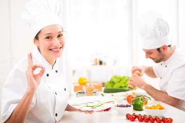 Young attractive professional chef cooking in his kitchen