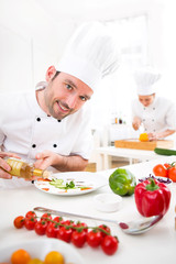 Young attractive professional chef cooking in his kitchen