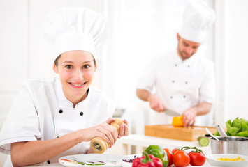 Young attractive professional chef cooking in his kitchen
