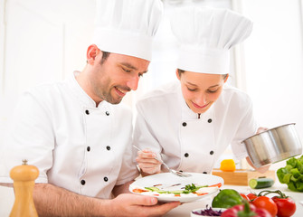 Young attractives professionals chefs cooking together