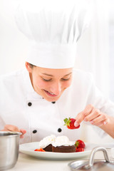 Young attractive professional chef cooking in his kitchen