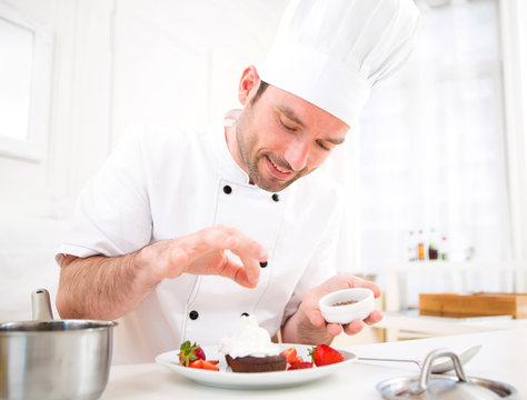 Young Attractive Professional Chef Cooking In His Kitchen