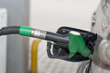 Fuel nozzle during refueling at a gas station.