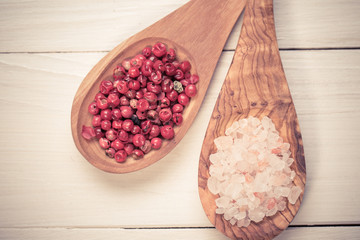himalayan salt and red grain of pepper on wooden spoons