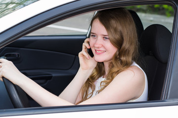 Obraz na płótnie Canvas woman with the phone behind the wheel of car