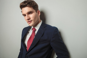 handsome young business man leaning on a wall