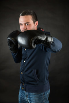 Handsome man with black boxing gloves. A concept of a challenge.