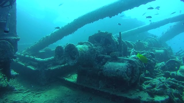 diver inspects the winch mechanism on shipwreck 
