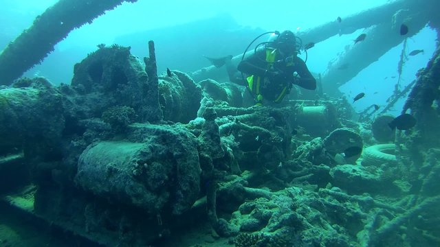 diver inspects the winch mechanism on shipwreck  