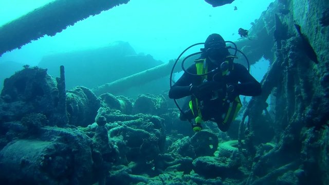 diver inspects the winch mechanism on shipwreck Thistlegorm 