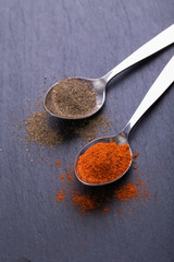 Sliced, dried, red chili peppers and seeds on a stones background