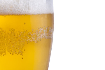 Golden cold beer with white froth.