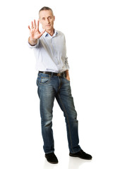 Mature man making stop sign
