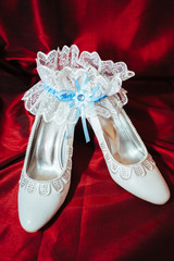Luxury wedding shoes. Elegant bridal shoes and a white garter on