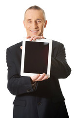 Happy businessman holding digital tablet