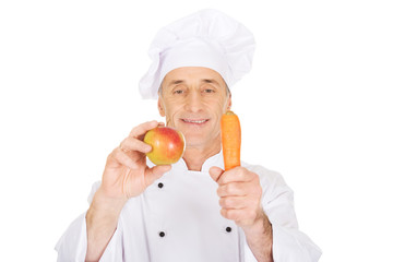 Male chef with an apple and carrot