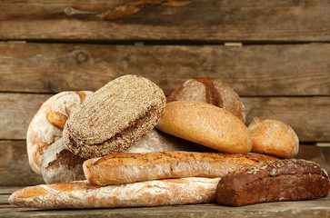 Different fresh bread on old wooden table