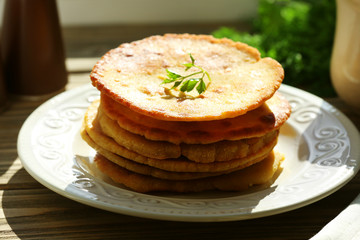Stack of corn tortillas with stuffing and greens on wooden table background
