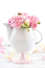 Beautiful spring flowers in teapot isolated on white