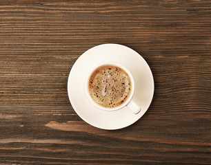 Cup of coffee on wooden table, top view