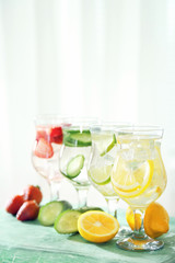 Glasses of different home made freshness healthy vitamin-fortified water on wooden table