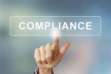 business hand clicking compliance button on blurred background