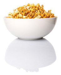 Caramel popcorn in white bowl over white background
