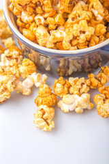 Caramel popcorn in blue pot over white background