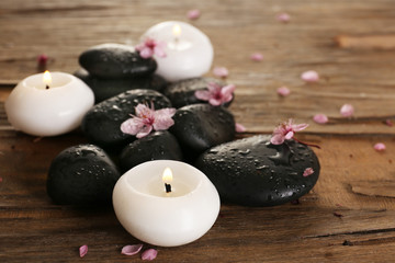 Spa stones with candles and spring flowers on table close up