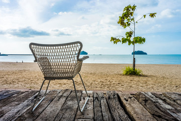 Khlong Wan beach with silhouette of wicker chair on wooden log d