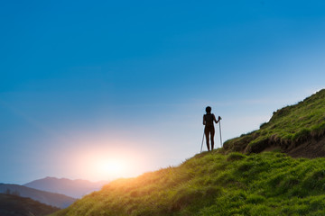 Obraz premium Silhouette of girl that makes trekking at sunset