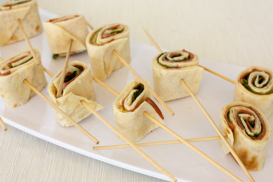 Rotoli di prosciutto e verdura tenuti da bastoncini di legno