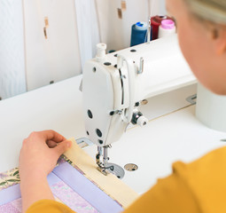 Woman working on sewing machine in the factory.