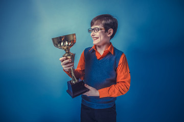 European-looking  boy of  ten years in glasses holding a cup awa - obrazy, fototapety, plakaty