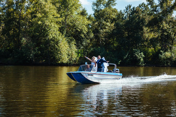 Newly married couple riding in boat on river