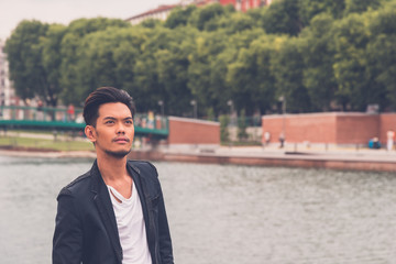 Handsome Asian model posing by an artificial basin