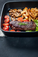 Fried steak with fries .
