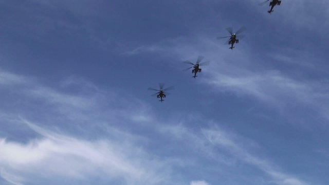 military helicopters flying formation on the blue sky