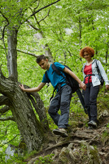 Naklejka na ściany i meble Family of hikers walking on a mountain trail