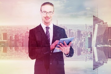 Composite image of happy businessman using his tablet pc 