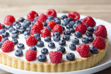 Cake with blueberries and raspberries. Confectionery product.