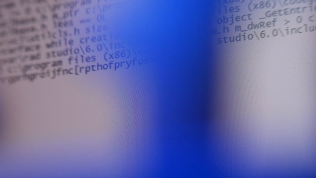 Hacker typing spy program. The virus code is on the screen