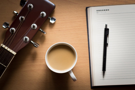 hot coffee with guitar and notepad on table break time for think