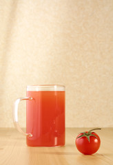 Red tomato and a glass of juice