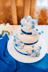 Obraz na płótnie Canvas multi level white wedding cake on silver base and pink flowers