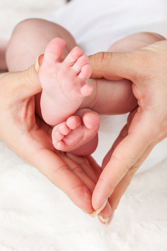 Mother holding newborns feet