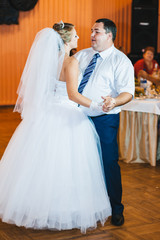 Naklejka premium beautiful caucasian couple just married and dancing their first
